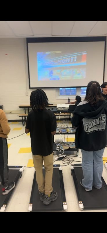 Students playing games while walking on treadmills
