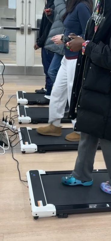 Kids holding controllers on walking pads